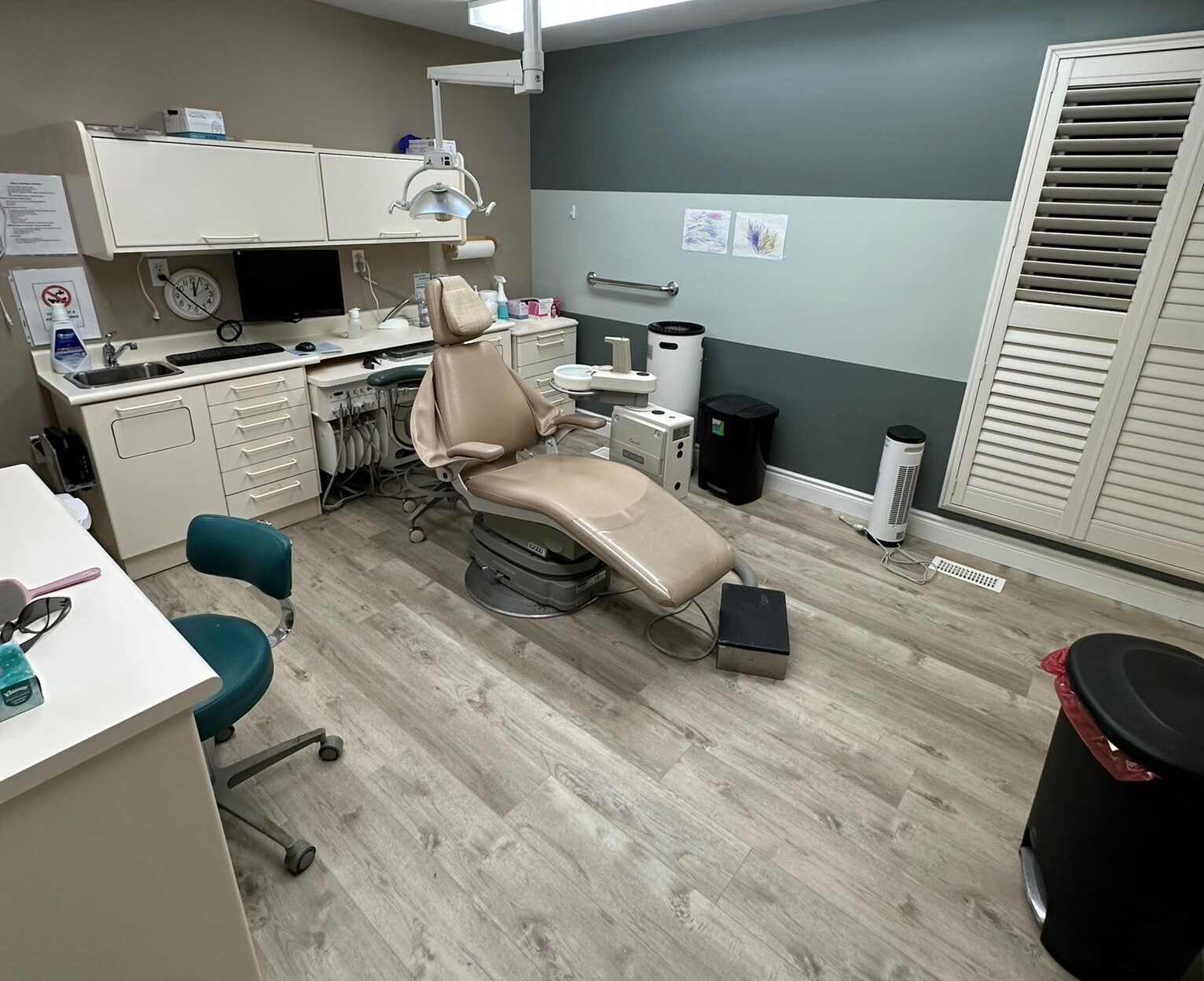 A repainted operatory with a new grey accent wall and wood-look floor.