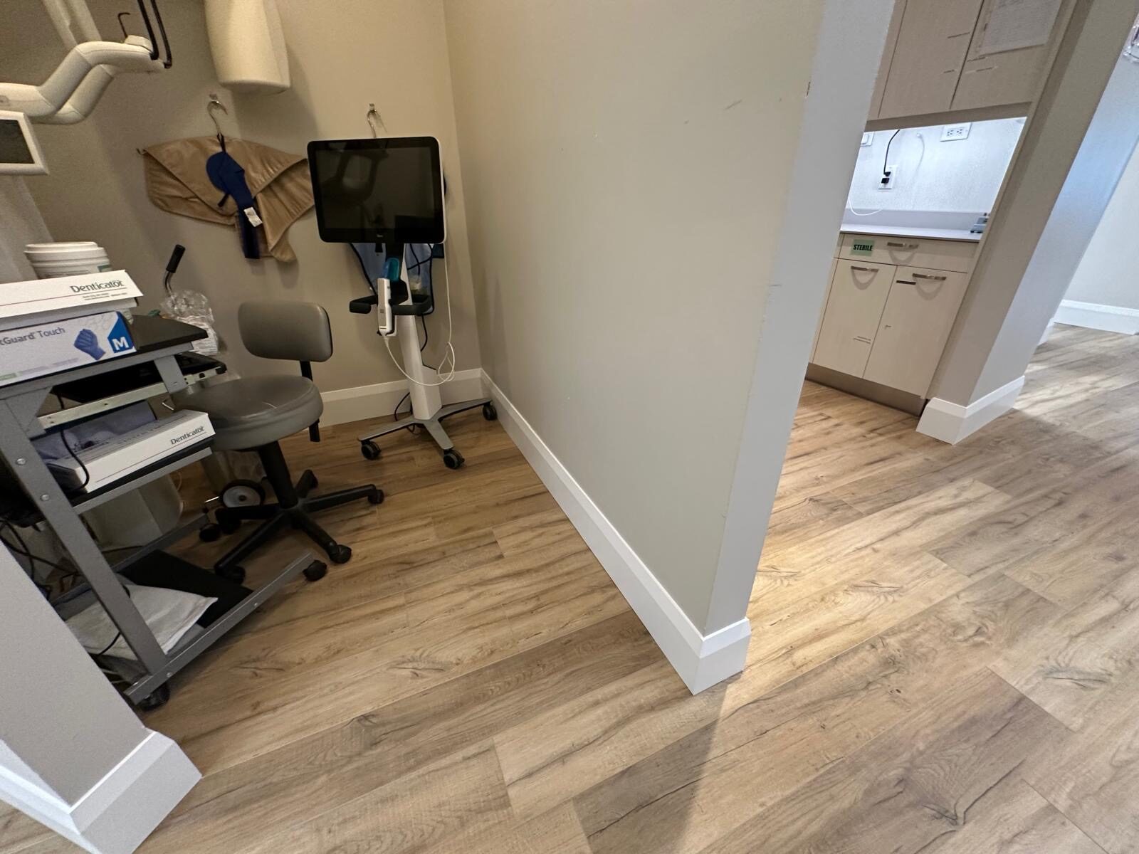 A finished operatory with new light wood-look LVT flooring.