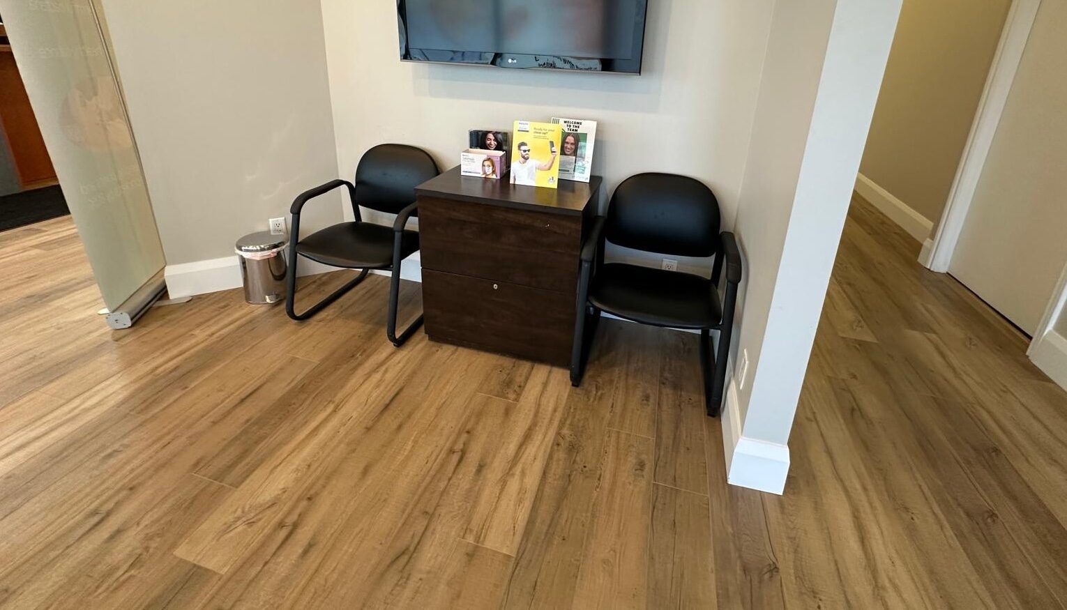 New flooring runs the length of the clinic hallways with fresh baseboards, replacing the original tile and carpet.