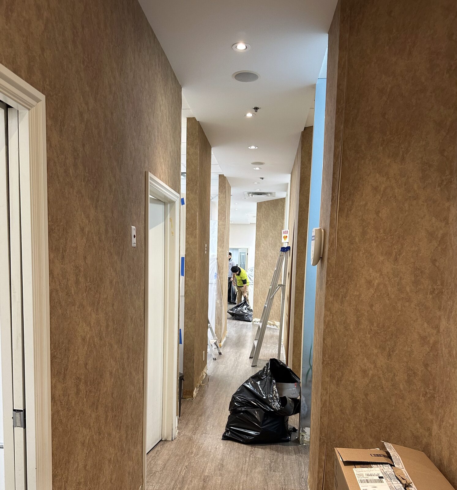 Wallpaper stripped and walls prepped in the hallway during the after-hours work.