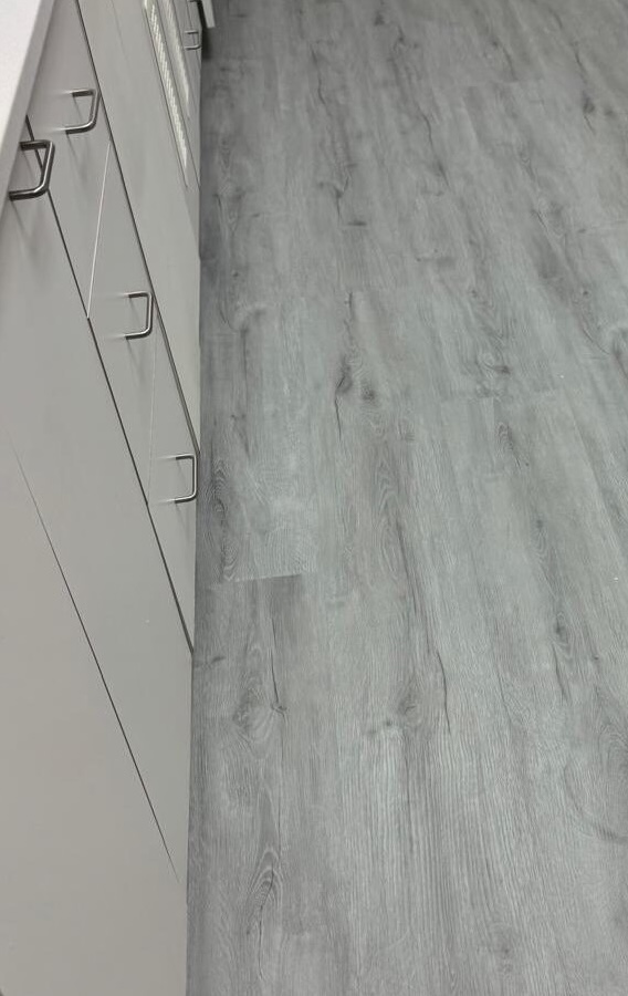 Close-up of the new grey wood-look luxury vinyl flooring.